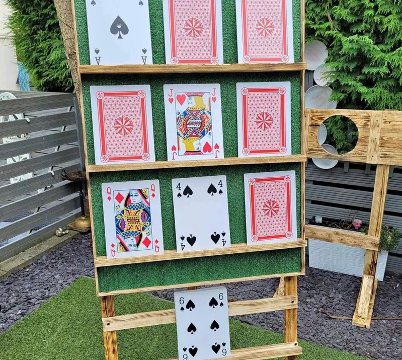 Handmade Play Your Cards Right board on a wooden easel in a garden